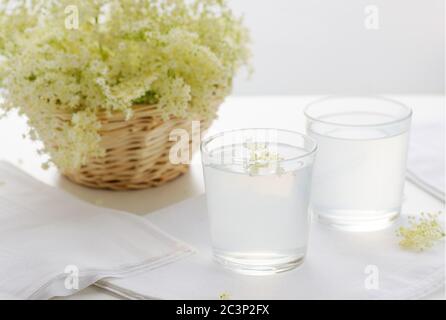 Limonade de sureau et fleur de sureau sur fond blanc, rafraîchissante et saine.image avec foyer sélectif, horizontale. Banque D'Images