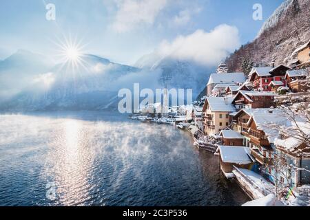 Vue classique de carte postale de la célèbre ville de Hallstatt au bord du lac dans les Alpes avec le soleil levant au-dessus des sommets de montagne, le matin glacial en hiver, Salzkammer Banque D'Images