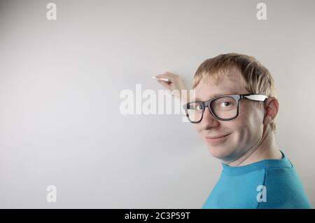 Vue en gros plan d'un homme caucasien portant un t-shirt bleu et des lunettes tout en prétendant écrire Banque D'Images