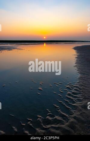 Coucher de soleil vertical avec des ondulations de sable sur la plage d'Ostende (Ostende), Flandre Occidentale, Côte de Belgique. Banque D'Images