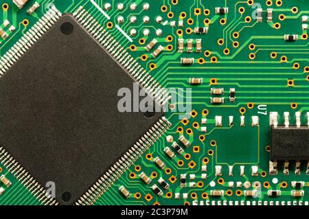 Gros plan de la carte de circuit imprimé électronique avec puce, processeur, circuits intégrés, résistances et connexions électroniques. Banque D'Images