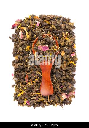 Nouez le thé Guan Yin avec les pétales de lilas, d'hibiscus et de tournesol, isolés sur fond blanc. Thé vert biologique. Vue de dessus. Gros plan. Banque D'Images