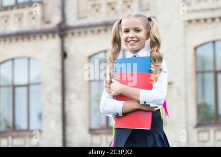 Une école de qualité. Étudier la littérature pour les enfants. Apprendre avec dossier de documents. Journée de la connaissance. Éducation scolaire moderne. Enfance heureuse. Jeune fille avec livre. Jolie petite fille va lire. Banque D'Images