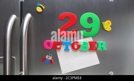 Octobre 29 date calendaire faite avec des lettres magnétiques en plastique tenant une note de papier graphique sur le réfrigérateur de porte Banque D'Images
