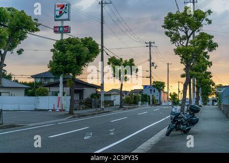 Kobe, Japon - 19 juin 2020 : moto garée sur une rue vide devant un dépanneur au coucher du soleil Banque D'Images