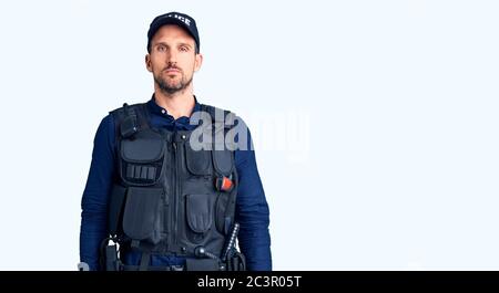 Jeune homme beau portant l'uniforme de police, qui a l'air endormi et fatigué, épuisé pour la fatigue et le hangover, les yeux paresseux le matin. Banque D'Images