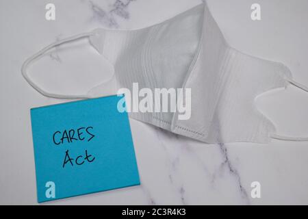 CARES Act écrire sur le billet collant isolé sur la table en bois. Banque D'Images