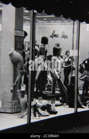 Fine fenêtre vintage des années 70 noir et blanc avant du magasin pleine de mannequins féminins vêtus des dernières mode. Banque D'Images