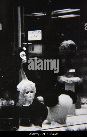 Fine fenêtre vintage des années 70 noir et blanc avant du magasin pleine de mannequins féminins vêtus des dernières mode. Banque D'Images
