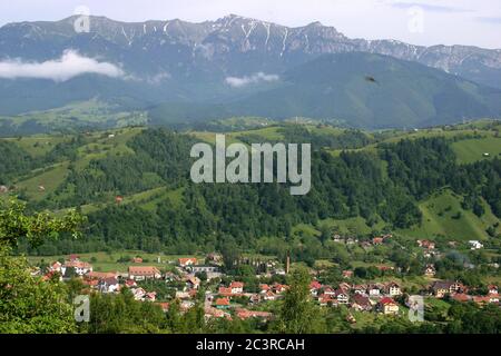 L'été dans les Carpates Mountains, Roumanie. Bucegi MTS. Vue de Piatra CRAiului MTS., avec village dans la vallée. Banque D'Images