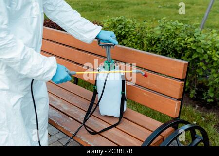vue de culture d'un spécialiste de la combinaison de matières dangereuses et d'un banc de désinfection de respirateurs dans le parc pendant une pandémie de coronavirus Banque D'Images