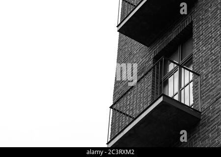Photo en niveaux de gris d'une façade de bâtiment en brique sur un blanc fond ciel Banque D'Images
