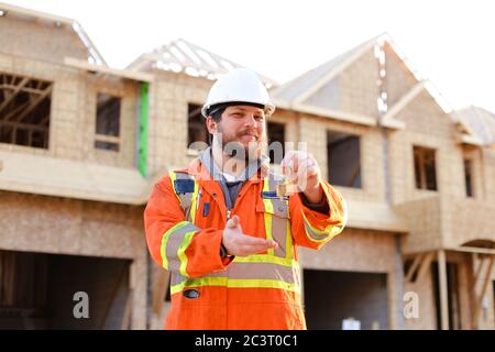 Portrait d'un ingénieur européen qui donne les clés d'une nouvelle maison. Banque D'Images