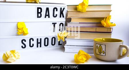 Visionneuse avec TEXTE ET livres DE RETOUR À L'ÉCOLE sur fond blanc avec papier jaune froissé Banque D'Images