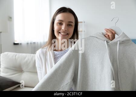 Femme montrant à la caméra blanc branché à capuche filmant vidéo promotionnelle Banque D'Images