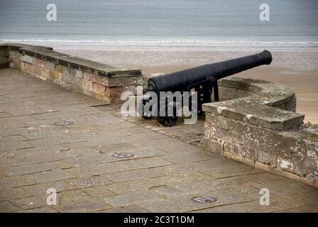 Cannon sur les remparts du château de Bamburgh, Northumberland Banque D'Images