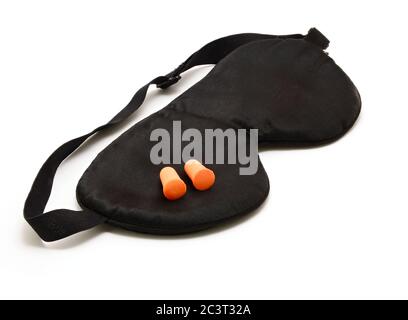 Masque de sommeil noir avec paire de bouchons d'oreilles en mousse orange sur fond blanc. Banque D'Images