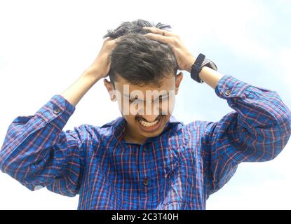 Jeune homme souffrant de maux de tête forts ou de fond migrant.Sky. Banque D'Images