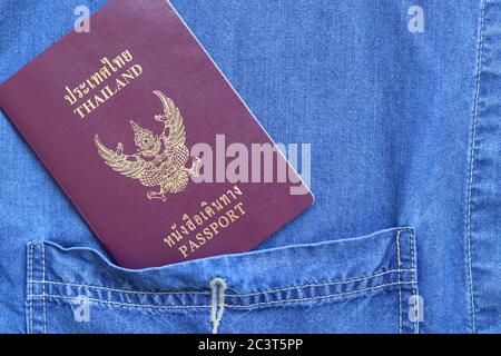 Vue du dessus Passeport de Thaïlande placé sur la poche de chemise jean avec espace pour copier. Concept de voyage et de tourisme sur fond bleu avec passeport thaïlandais. Banque D'Images