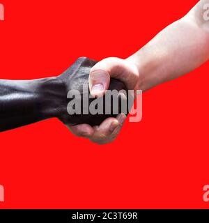 Deux hommes de différentes races tenant les mains ensemble sur fond rouge. La photo montre l'amitié, le soutien, l'égalité et la diversité. Un caucasien, l'autre est noir ou foncé. Les vies noires comptent. Pas de concept de racisme. Banque D'Images