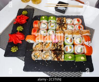 Ensemble de sushis. Différents types de sushis Maki et Nigiri avec sauce au gingembre et au wasabi. Service coloré au restaurant. Banque D'Images