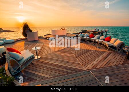 Détendez-vous dans un espace salon près de la mer calme dans un hôtel de luxe sur les rives de l'océan Indien. Vue sur le coucher du soleil dans un complexe tropical Banque D'Images