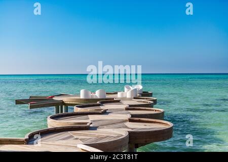 Chaises longues sur la plage des Maldives. Détendez-vous dans un espace salon près de la piscine dans un hôtel de luxe sur les rives de l'océan Indien Banque D'Images