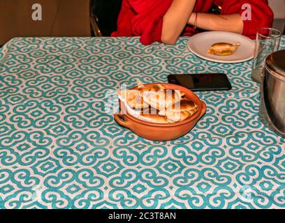 Femme mangeant des empanadas, plat typique de l'Argentine, artisan en céramique avec la poterie indigène similaire avec des empanadas frais maison (detai Banque D'Images