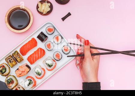 Sushi avec saumon sur fond rose, vue du dessus. Banque D'Images