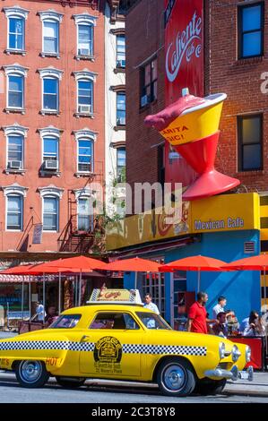 1950 Studebaker taxi jaune à l'extérieur de la caliente restaurant mexicain de la cabine sur la Septième Avenue, Greenwich Village, New York City, USA. Banque D'Images