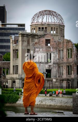 Moine bouddhiste contemplant le Mémorial de la paix d'Hiroshima (Dôme de la bombe atomique) Banque D'Images