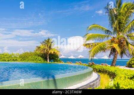 Secteur piscine en front de mer avec des chaises submergées dans un resort de luxe aux Maldives, l'Océan Indien Banque D'Images