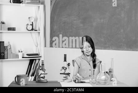 Formation en biologie. Leçon de science. Laboratoire scolaire. Petite fille au microscope. Tubes de test de classe biologie pour fille. Expérience scientifique. Leçon fascinante. Explorez la microbiologie. Étude de la biologie. Banque D'Images