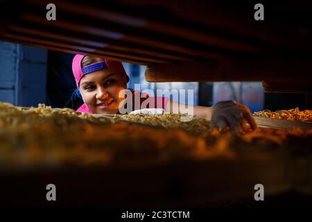 La fille travaille sur la production de spaghetti. Préparation de nouilles. Usine de pâtes. Banque D'Images