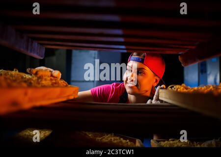 La fille travaille sur la production de spaghetti. Préparation de nouilles. Usine de pâtes. Banque D'Images