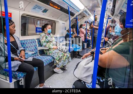 Londres, Royaume-Uni. 22 juin 2020. Quelques personnes continuent d'ignorer les instructions de port du masque ou ne savent pas comment le porter - les numéros de passagers restent considérablement bas sur le tube, même pendant les heures de pointe après l'assouplissement des directives gouvernementales. Ceux qui voyagent presque tous portent des masques après qu'ils sont devenus obligatoires dans les transports publics. Le « verrouillage » se poursuit pour l'épidémie du coronavirus (Covid 19) à Londres. Crédit : Guy Bell/Alay Live News Banque D'Images