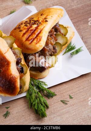 Rouleaux parfumés à la viande et aux cornichons et aneth sur une assiette blanche sur une table rustique. Concept de cuisine de rue. Banque D'Images