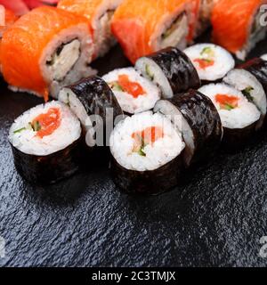 Divers types de sushis servis sur fond de pierre. Banque D'Images