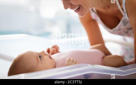 Portrait de belle maman aimante jouant les premiers jeux avec son bébé Banque D'Images