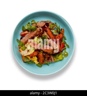 Un délicieux bol de lanières de steak de botte de barbecue, de croustilles de potatoe et de légumes, dans un bol bleu clair isolé sur un fond blanc Banque D'Images