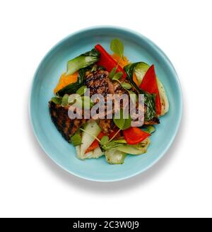 Un délicieux bol de filet de steak de rumsteck, purée de potatoe douce, poivrons rouges et légumes, dans un bol bleu clair isolé sur un fond blanc Banque D'Images