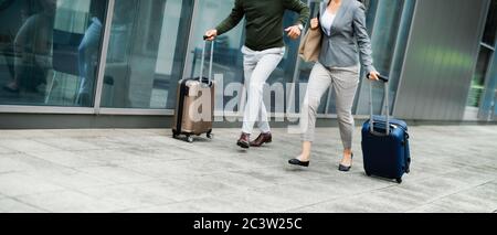 Milieu de la clientèle d'affaires avec bagages en voyage d'affaires, en courant à l'aéroport. Banque D'Images