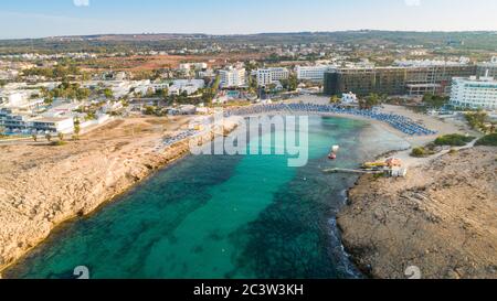 Vue panoramique sur la plage de Vathia Gonia, Ayia Napa, Famagusta, Chypre. L'attraction touristique historique baie rocheuse au lever du soleil avec sable doré, soleil Banque D'Images