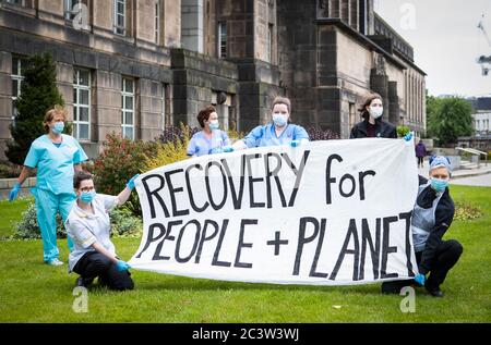 Les principaux manifestants, dont un ouvrier, un médecin et un soignant, ainsi que les grévistes écossais de la jeunesse, tiennent une bannière disant « récupération pour les gens et la planète » devant la maison St Andrew, le siège du gouvernement écossais, à Édimbourg, lors d'une manifestation organisée par les amis de la Terre. Banque D'Images