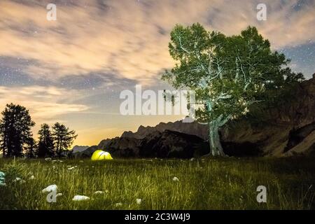 Une tente brille sous un ciel étoilé à l'heure du crépuscule. Alpes juliennes, Parc national de Triglav, Slovénie, montagne Slemenova, Sleme. Banque D'Images
