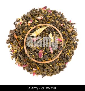 Nouez le thé Guan Yin avec les pétales de lilas, d'hibiscus et de tournesol, isolés sur fond blanc. Thé vert biologique. Vue de dessus. Gros plan. Banque D'Images