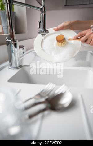 Femme se lavant à la maison à l'aide de la brosse Eco pour un style de vie durable Banque D'Images