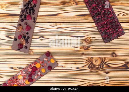 différents types de chocolat avec fruits séchés sur une planche en bois Banque D'Images
