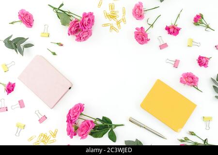 Composition de cadres avec bloc-notes, stylo et roses sur fond blanc. Pose à plat. Banque D'Images