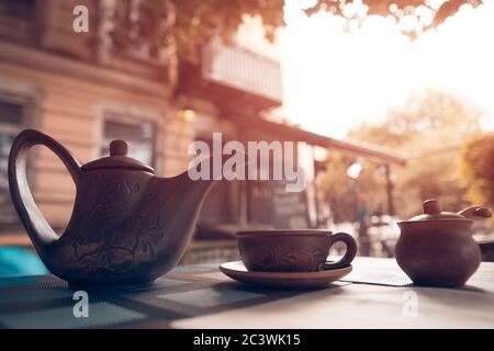 bouilloire à thé vintage avec tasse à l'extérieur au coucher du soleil Banque D'Images